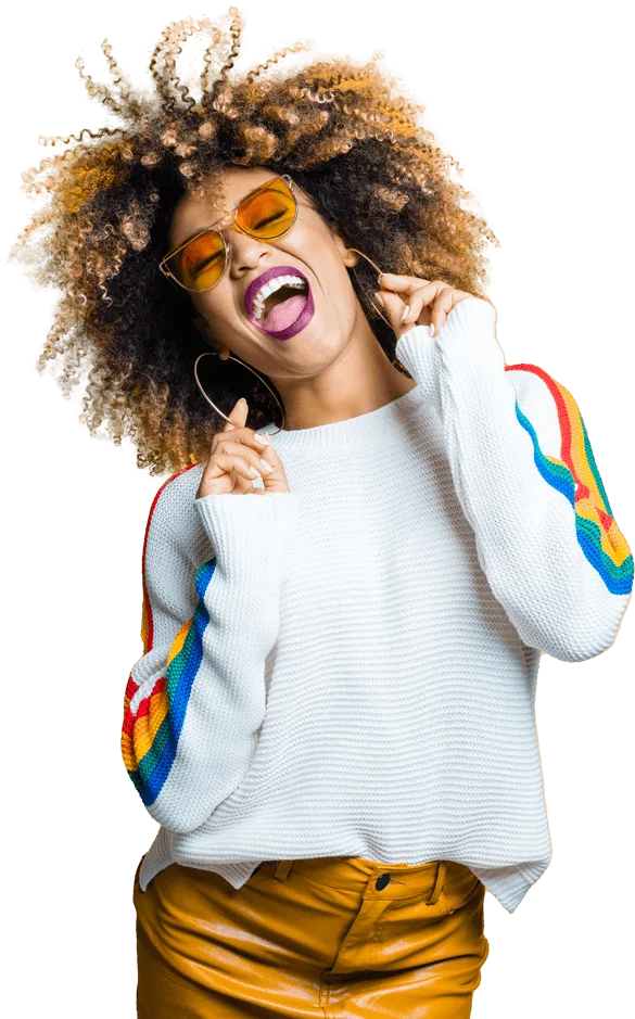 Woman with curly hair wearing sunglasses smiling and dancing
